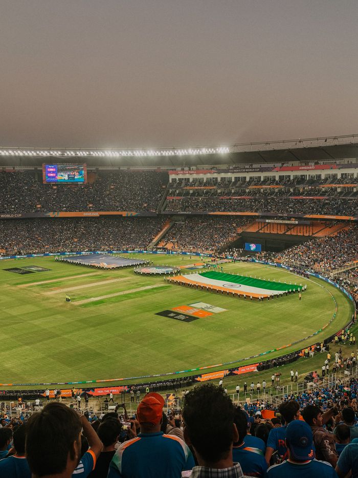 gallery-5 A vibrant cricket match at Narendra Modi Stadium with a packed crowd in Ahmedabad, India.
