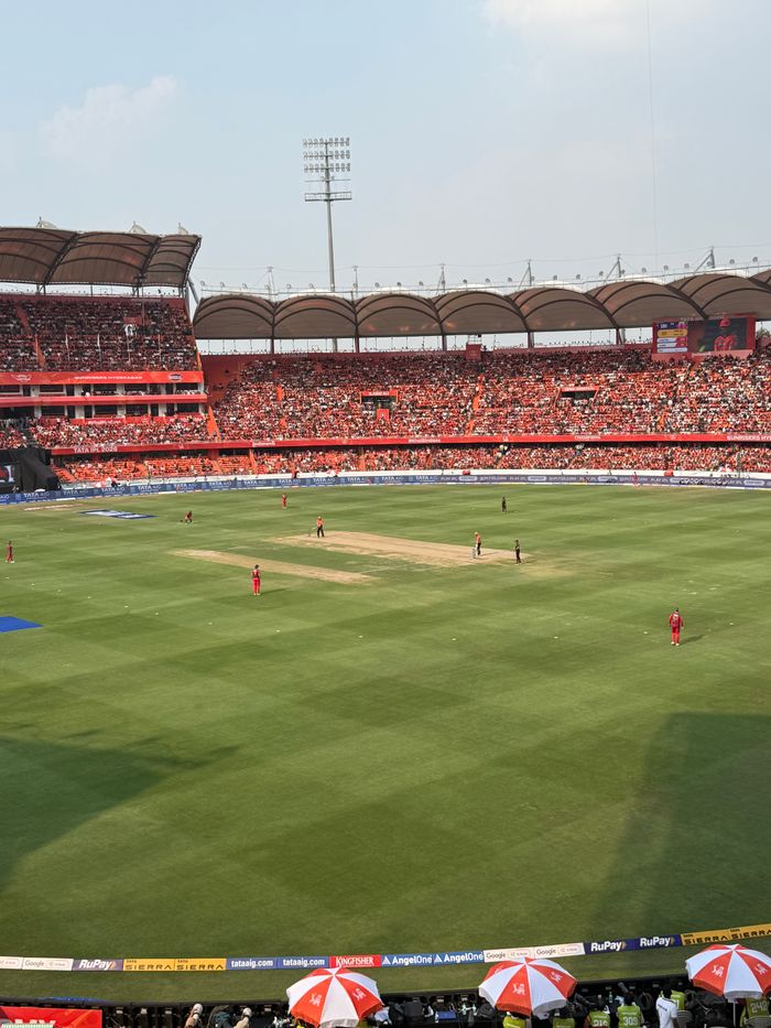 A thrilling daytime cricket match in a packed Hyderabad stadium with vibrant atmosphere.